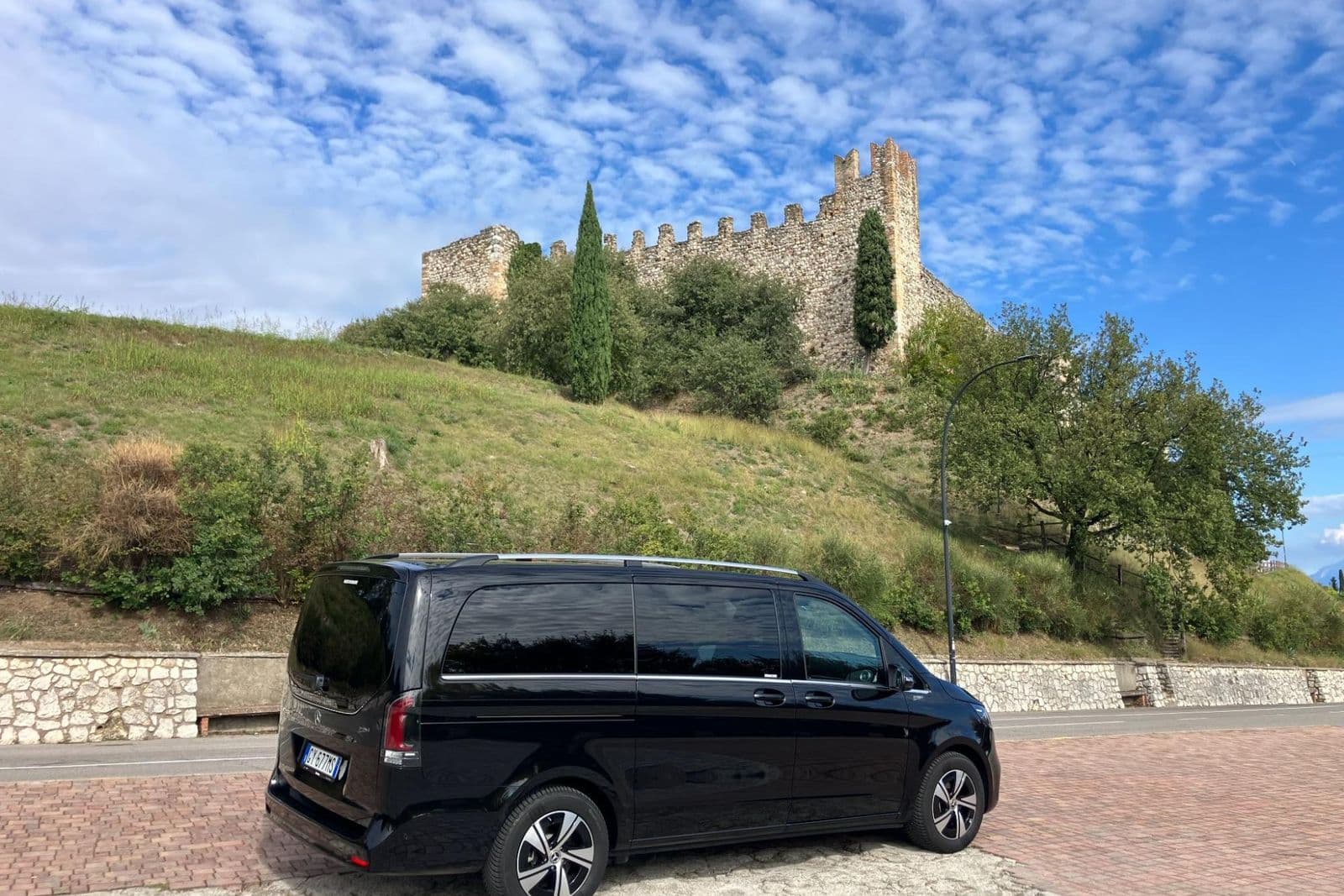 GardaTaxi's Mercedes V-Class in front of the walls of a castle on Lake Garda